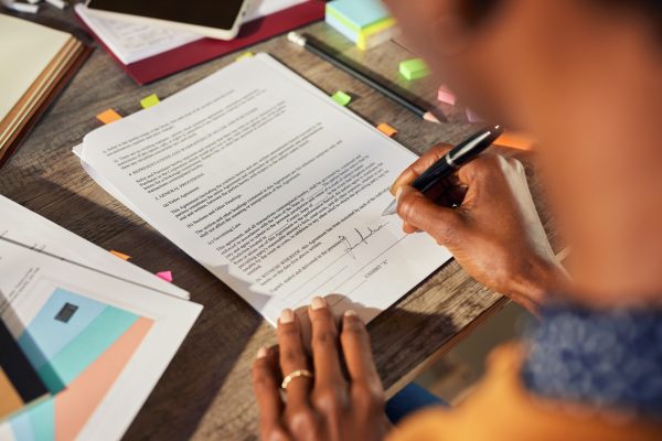 African american woman hand signing buiness contract